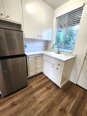 Sunnyvale apartment for rent - a small kitchen with white cabinets and a stainless steel refrigerator