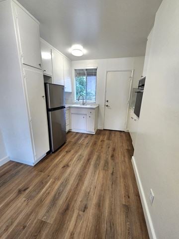 Sunnyvale apartment for rent - A kitchen with a refrigerator, sink, and wooden floors.