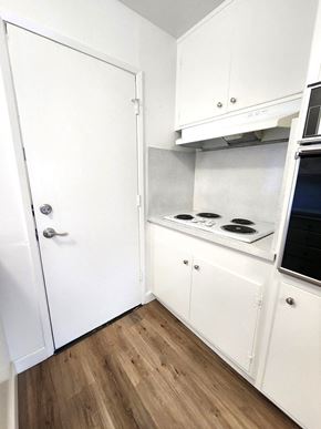 Sunnyvale apartment for rent - an empty kitchen with white cabinets and a stove top oven