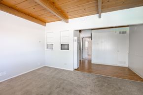 San Jose apartment for rent - an empty living room with a wood ceiling and white walls