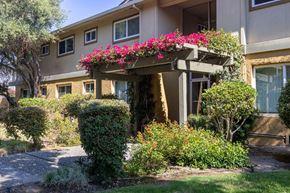 San Jose apartment for rent - the front entrance of an apartment building with pink flowers on a porch
