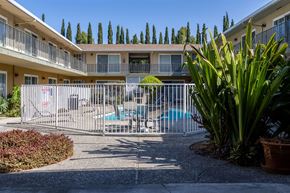 San Jose apartment for rent - a building with a pool and a fence in front of it