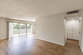 Los Gatos townhouse for rent - the living room and dining room of an empty house with wood floors and a balcony