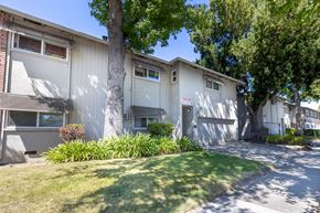 San Jose apartment for rent - a white apartment building with a lawn and trees