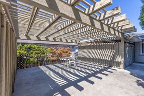 San Jose apartment for rent - a covered patio with a table and chairs under a wooden roof