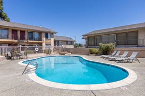 San Jose apartment for rent - a swimming pool with chairs around it in front of a house