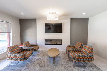 Gilroy apartment for rent - A living room with a fireplace and a television mounted on the wall.