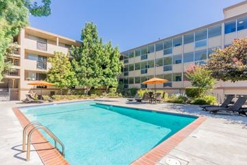 San Jose apartment for rent - a swimming pool with an office building in the background
