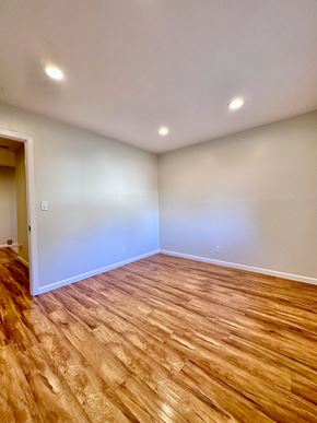 Redwood City apartment for rent - an empty living room with wood flooring and white walls