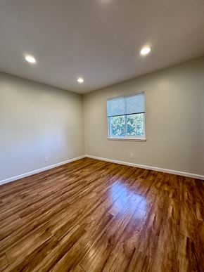 Redwood City apartment for rent - an empty living room with wooden floors and a window