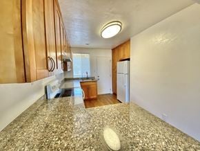 Sunnyvale apartment for rent - A kitchen with granite countertops and wooden cabinets.