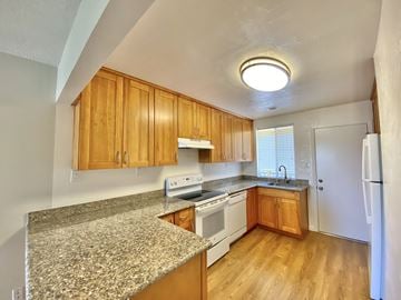 Sunnyvale apartment for rent - A kitchen with wooden cabinets and a granite countertop.