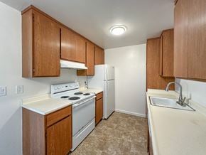 San Carlos apartment for rent - A kitchen with white appliances and wooden cabinets.