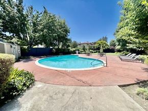 San Jose townhouse for rent - a backyard pool with trees and a blue fence around it