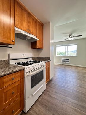 Los Gatos townhouse for rent - an empty kitchen with wooden cabinets and a white stove