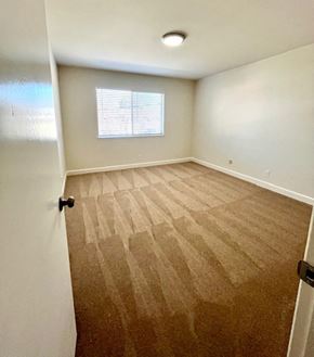 San Jose apartment for rent - A room with a carpeted floor and a window with blinds.