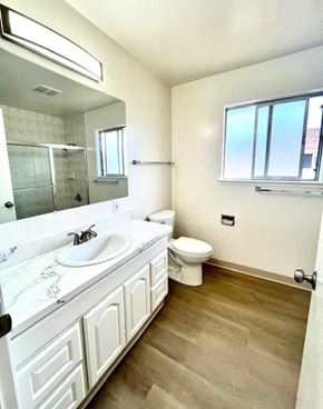 San Jose apartment for rent - A bathroom with a toilet, sink, and mirror.