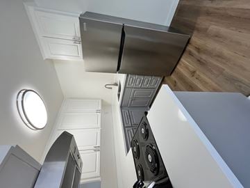 Mountain View apartment for rent - A modern kitchen with a stainless steel refrigerator and a wooden floor.