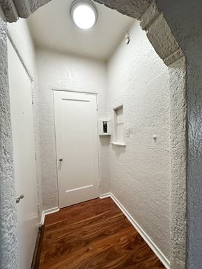 San Jose apartment for rent - A white door is in a hallway with wood floors and white walls.