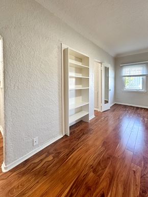 San Jose apartment for rent - A room with white walls and wooden floors with a window.