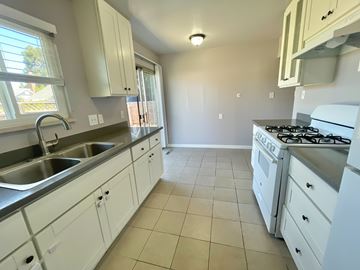 Castro Valley apartment for rent - A kitchen with white cabinets and a stove top oven.