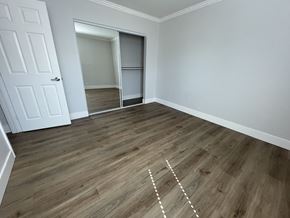 Cupertino apartment for rent - A room with a white door and wooden flooring with white lines drawn on it.