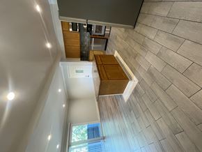 Cupertino apartment for rent - A view from the top of a staircase looking down to a landing with a window.