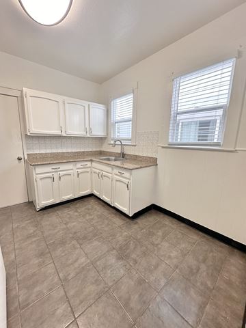 San Francisco apartment for rent - A kitchen with white cabinets and a tiled floor.