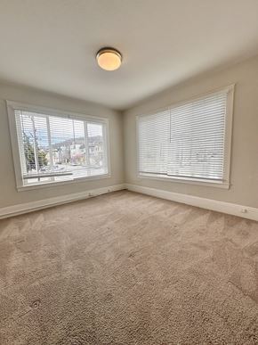San Francisco apartment for rent - A room with a carpeted floor and a window with blinds.