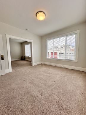 San Francisco apartment for rent - A room with a carpeted floor and a window with blinds.