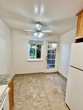 San Jose triplex for rent - A kitchen with a white refrigerator and a ceiling fan.