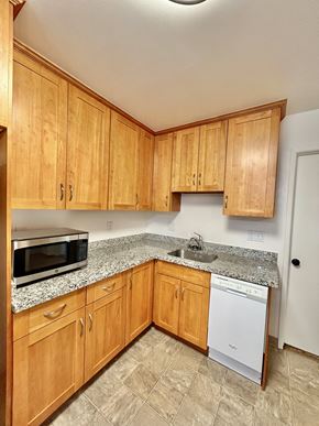 San Jose triplex for rent - A kitchen with wooden cabinets and a granite countertop.