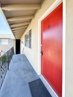 Santa Clara apartment for rent - a red door at the entrance to a building with a balcony