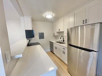 Santa Clara apartment for rent - A kitchen with a stainless steel refrigerator and white cabinets.
