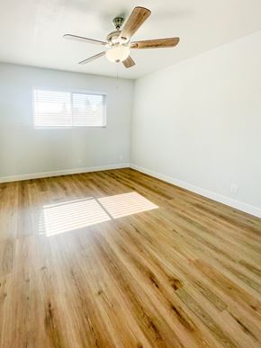 Redwood City apartment for rent - an empty living room with wood floors and a ceiling fan