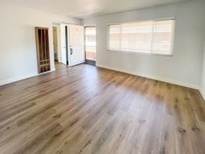 Redwood City apartment for rent - an empty living room with hardwood flooring and a window