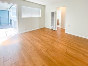 Santa Clara apartment for rent - an empty living room with hardwood flooring and a door to a bedroom