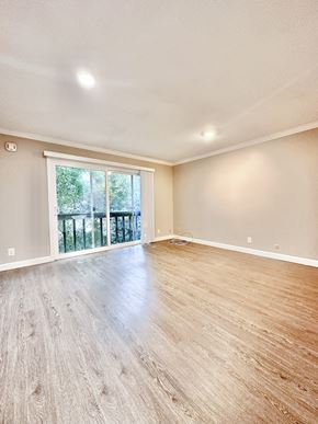 Burlingame apartment for rent - a living room with hardwood floors and a sliding glass door to a balcony