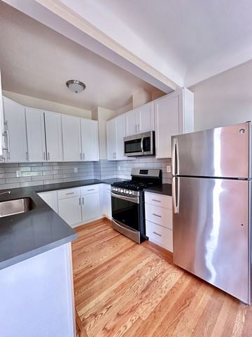 Burlingame apartment for rent - A kitchen with a stainless steel refrigerator and wooden floors.