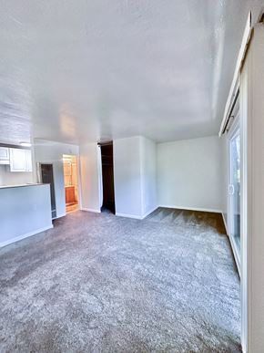 San Jose apartment for rent - an empty living room with a kitchen in the background