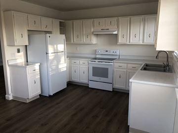 San Jose apartment for rent - A kitchen with white appliances and cabinets.