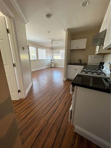 Menlo Park apartment for rent - A kitchen with white cabinets and a black countertop.