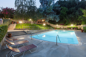 San Jose apartment for rent - A pool surrounded by trees and lights at night.