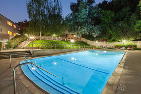 San Jose apartment for rent - A swimming pool at night with lights on.