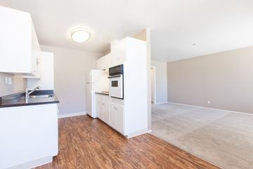 Mountain View apartment for rent - A kitchen with white cabinets and a wooden floor.