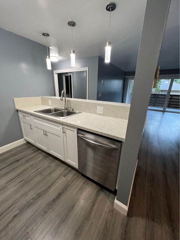 Redwood City apartment for rent - A modern kitchen with a stainless steel dishwasher and white countertops.
