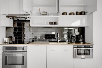 A modern kitchen with stainless steel appliances and white cabinetry.