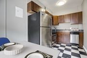 Washington apartment for rent - A black and white checkered floor in a kitchen with a stainless steel refrigerator.
