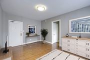 Washington apartment for rent - A living room with a white cabinet, a white door, a white wall, a white rug, a white plant, a white TV stand, a white framed picture, a white wall, a white ceiling, a white floor, a white