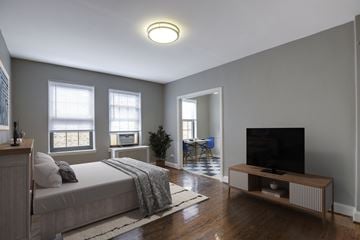 Washington apartment for rent - A bedroom with a bed, a television, and a chair.